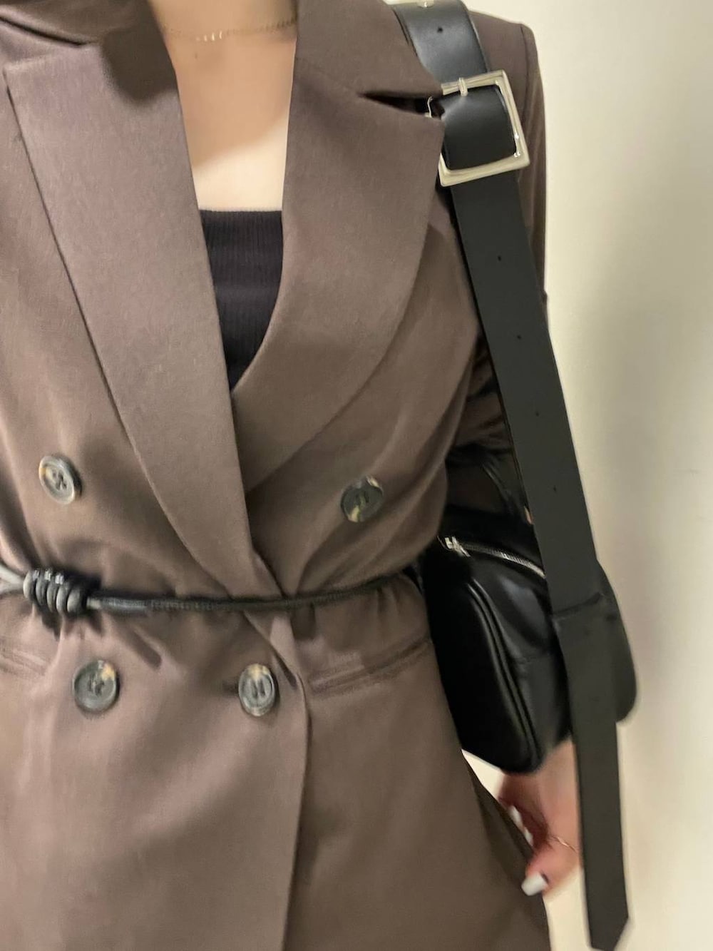 ブラウン系のテーラードジャケット、ブラック系のボストンバッグ、ブラウン系のスラックスを着用したレディースの冬コーディネートの3枚目の写真