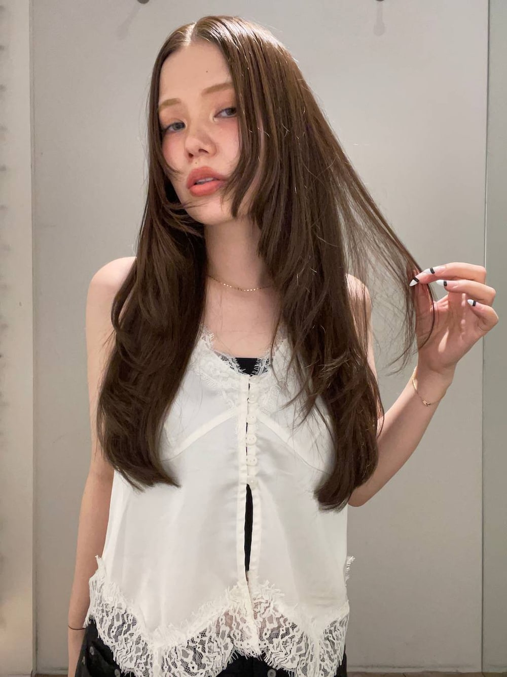 ブラック系のデニムパンツ、ホワイト系のベスト、ブラック系のベルトを着用したレディースの夏コーディネートの4枚目の写真