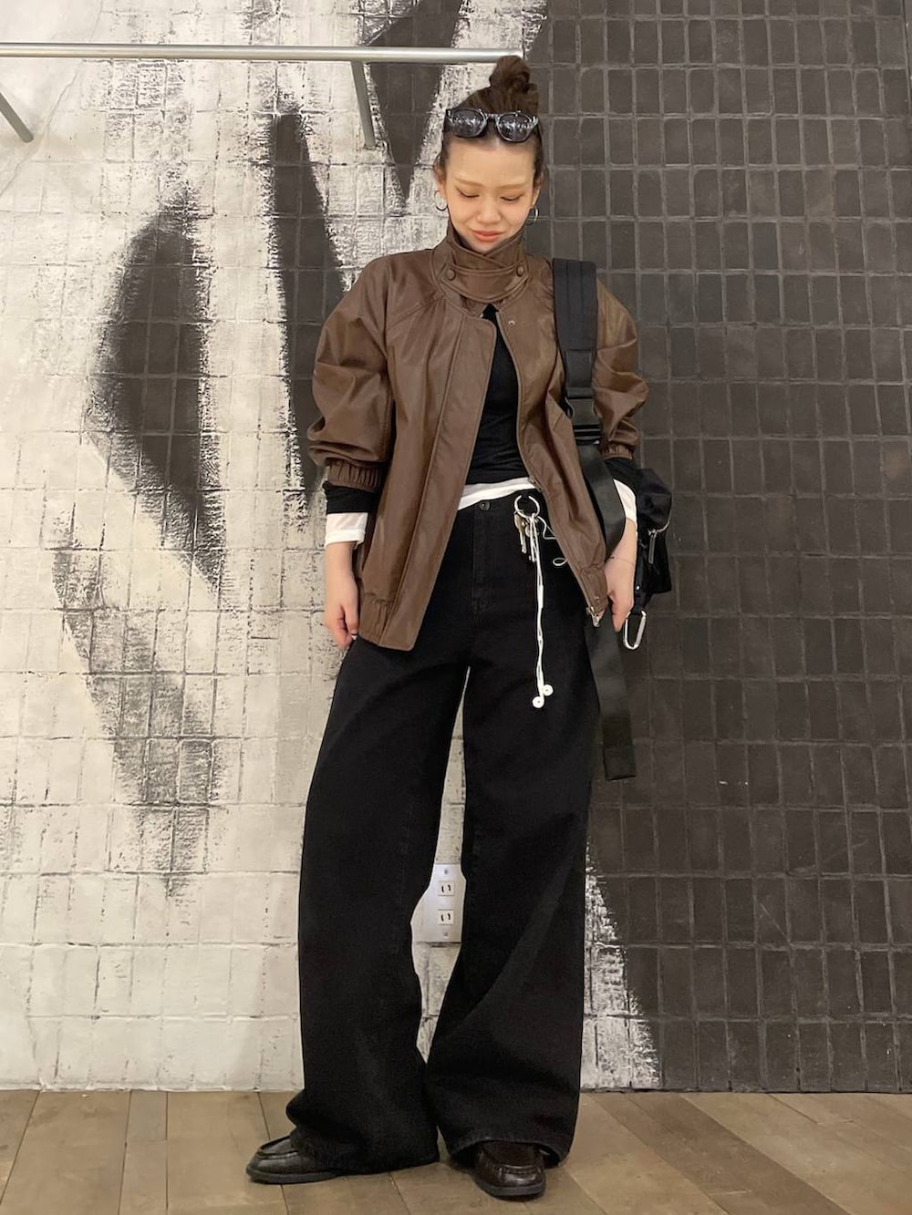 ブラック系のショルダーバッグ、ブラウン系のブルゾン、ブラック系のローファーを着用したレディースの春コーディネートの4枚目の写真