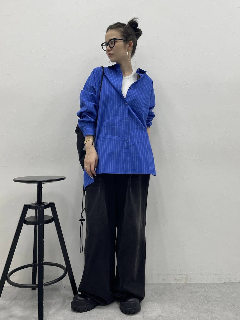 グレー系のデニムパンツ、ブラック系のブーツ、ブラック系のバックパック/リュックを着用したレディースの冬コーディネートの5枚目の写真