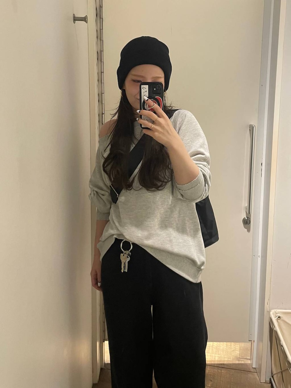 グレー系のスウェット、ブラック系のトートバッグ、ブラック系のデニムパンツを着用したレディースの冬コーディネートの6枚目の写真