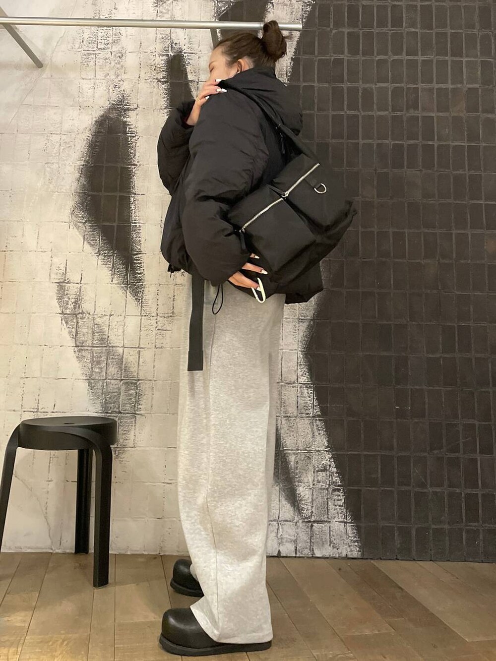 ブラック系のショルダーバッグ、ブラック系のその他シューズ、レッド系のニット/セーターを着用したレディースの冬コーディネートの3枚目の写真