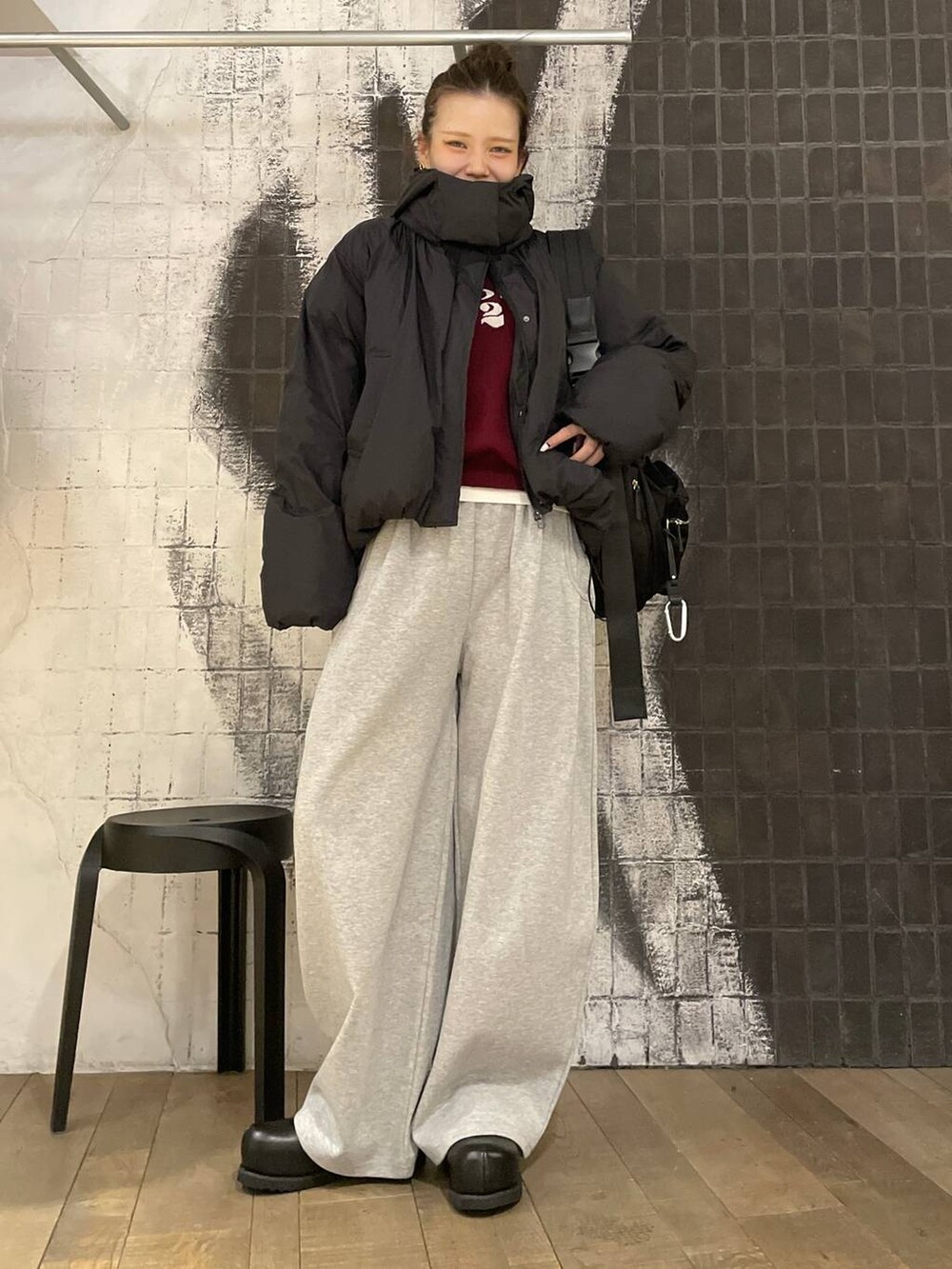 ブラック系のショルダーバッグ、ブラック系のその他シューズ、レッド系のニット/セーターを着用したレディースの冬コーディネートの4枚目の写真