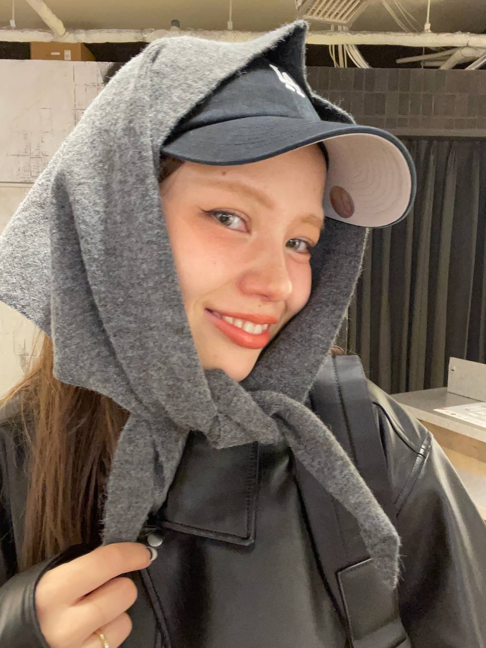 ブラック系のショルダーバッグ、グレー系のデニムパンツ、ブラック系のライダースジャケットを着用したレディースの秋コーディネートの6枚目の写真