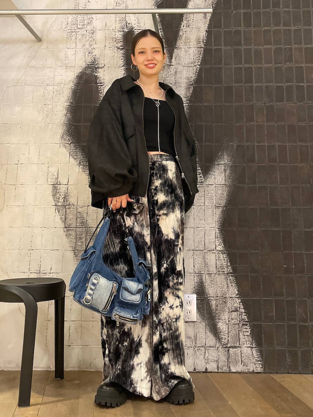 ブラック系のブルゾン、ブルー系のショルダーバッグ、ブラック系のブーツを着用したレディースの秋コーディネートの5枚目の写真