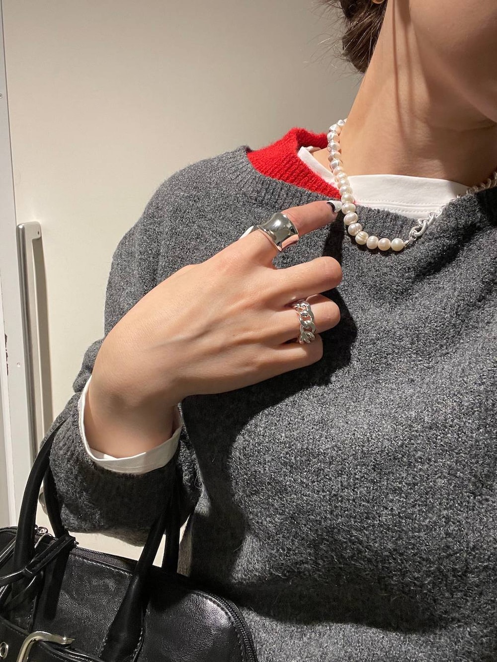 ブラック系のその他シューズ、ブラック系のボストンバッグ、ホワイト系のTシャツ/カットソーを着用したレディースの冬コーディネートの3枚目の写真