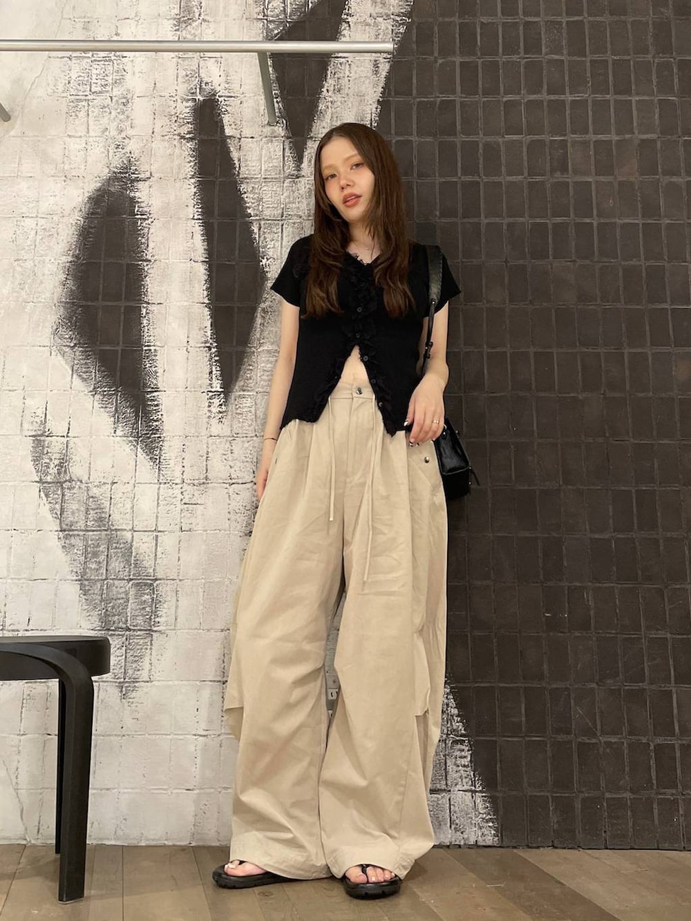 ベージュ系のその他パンツ、ブラック系のショルダーバッグ、ブラック系のサンダルを着用したレディースの夏コーディネートの6枚目の写真