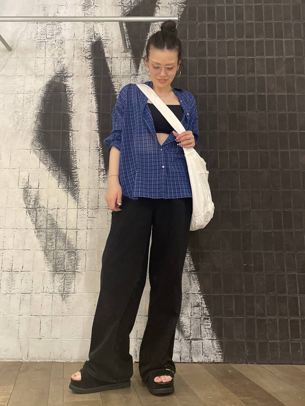 ブラック系のデニムパンツ、ブラック系のサンダル、ブルー系のシャツ/ブラウスを着用したレディースの春コーディネートの5枚目の写真