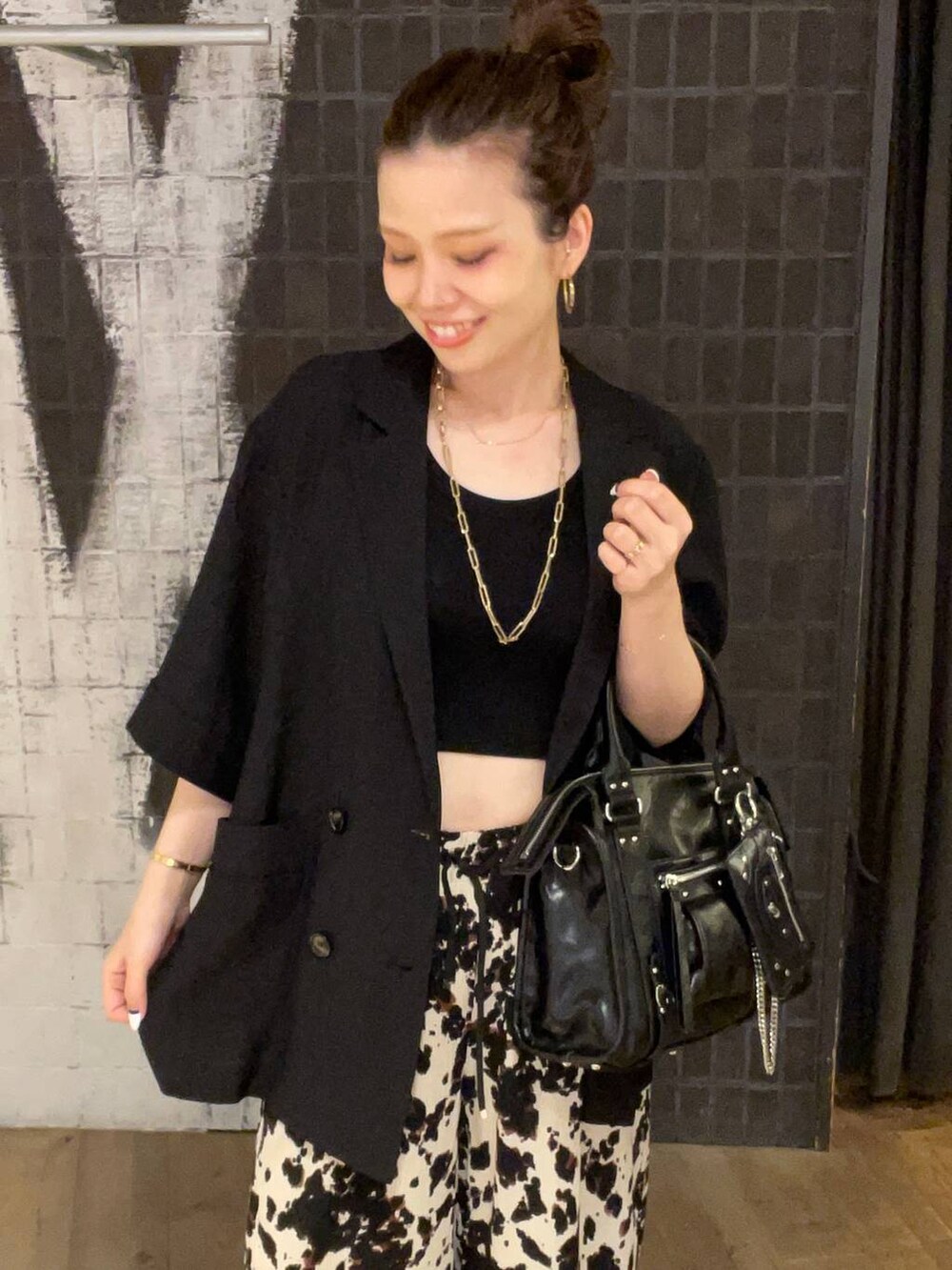 ブラック系のタンクトップ、ブラック系のボストンバッグ、ブラック系のサンダルを着用したレディースの夏コーディネートの5枚目の写真