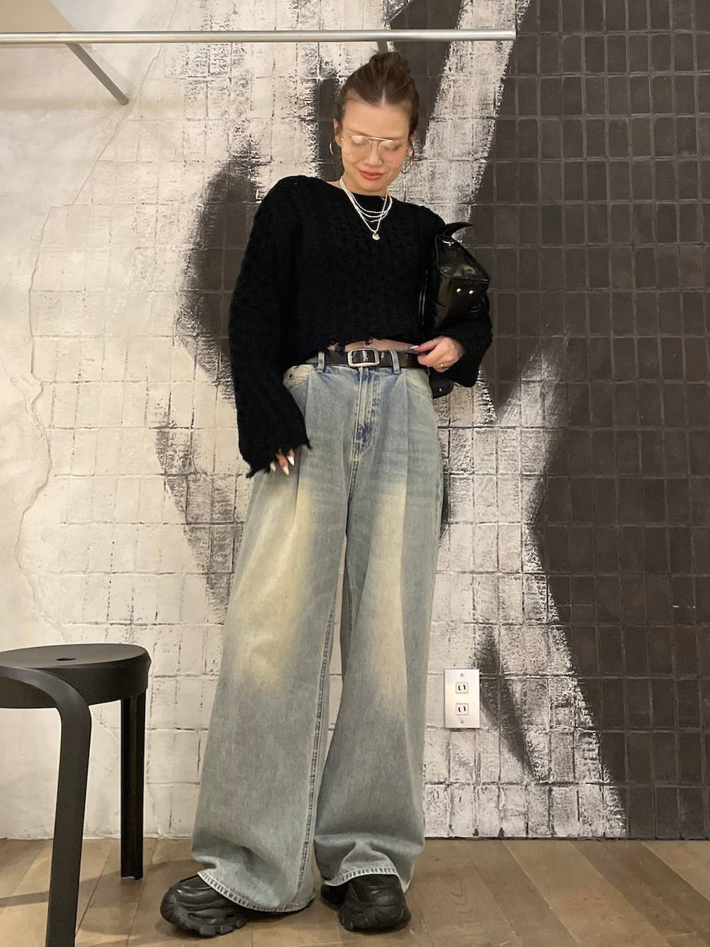 ブルー系のデニムパンツ、ブラック系のボストンバッグ、ブラック系のローファーを着用したレディースの秋コーディネートの2枚目の写真