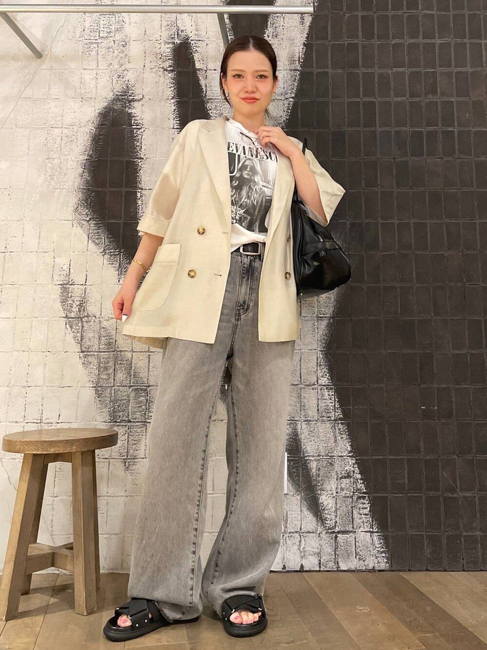 グレー系のデニムパンツ、ブラック系のボストンバッグ、ホワイト系のTシャツ/カットソーを着用したレディースの夏コーディネートの4枚目の写真