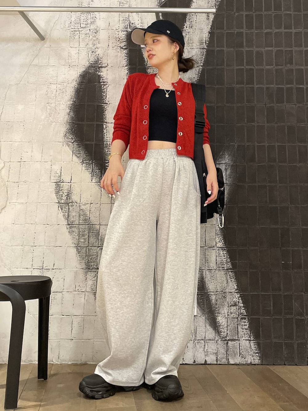 ブラック系のショルダーバッグ、ブラック系のブーツ、グレー系のスウェットパンツを着用したレディースの秋コーディネートの4枚目の写真