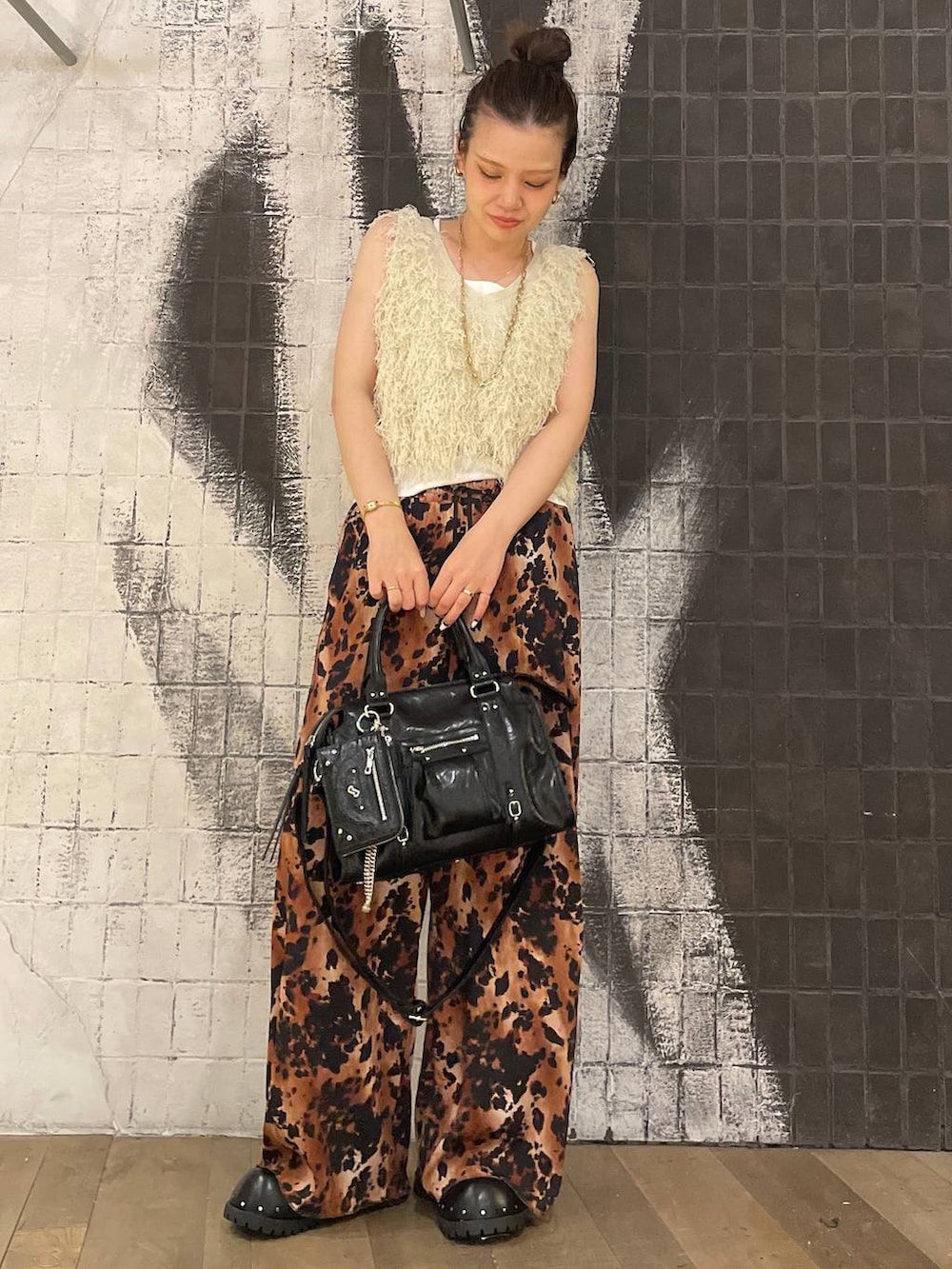 ブラック系のボストンバッグ、ホワイト系のタンクトップ、ブラック系のサンダルを着用したレディースの夏コーディネートの2枚目の写真