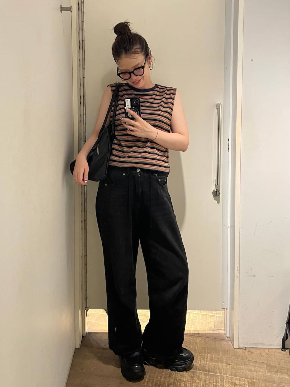 ブラウン系のボストンバッグ、レッド系のTシャツ/カットソー、ブラック系のローファーを着用したレディースの夏コーディネートの2枚目の写真