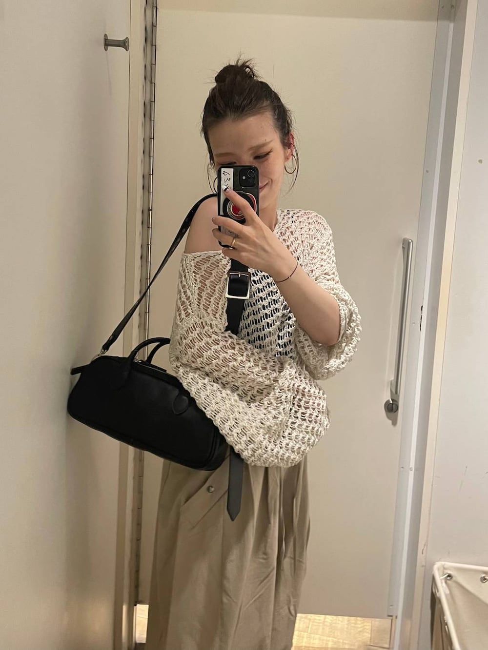 ブラック系のキャミソール、ブラック系のボストンバッグ、ブラック系のモカシン/デッキシューズを着用したレディースの春コーディネートの3枚目の写真