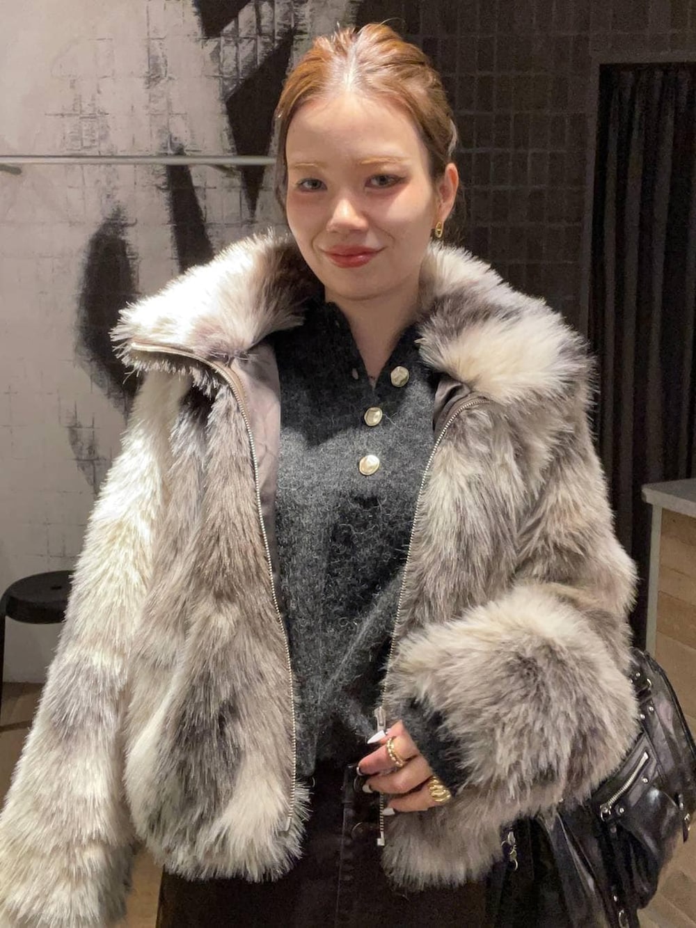 グレー系のブルゾン、ブラック系のその他シューズ、ブラウン系のデニムパンツを着用したレディースの冬コーディネートの5枚目の写真