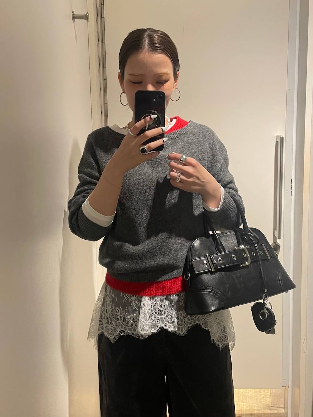 ブラック系のその他シューズ、ブラック系のボストンバッグ、ホワイト系のTシャツ/カットソーを着用したレディースの冬コーディネートの4枚目の写真