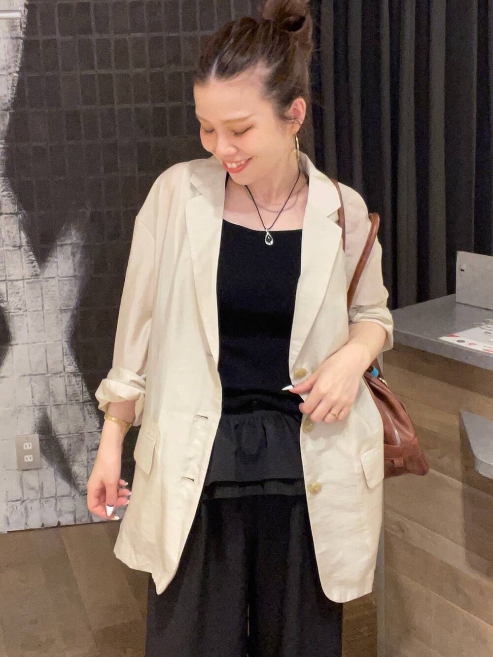 その他のサンダル、ブラウン系のボストンバッグ、ブラック系のその他パンツを着用したレディースの夏コーディネートの2枚目の写真