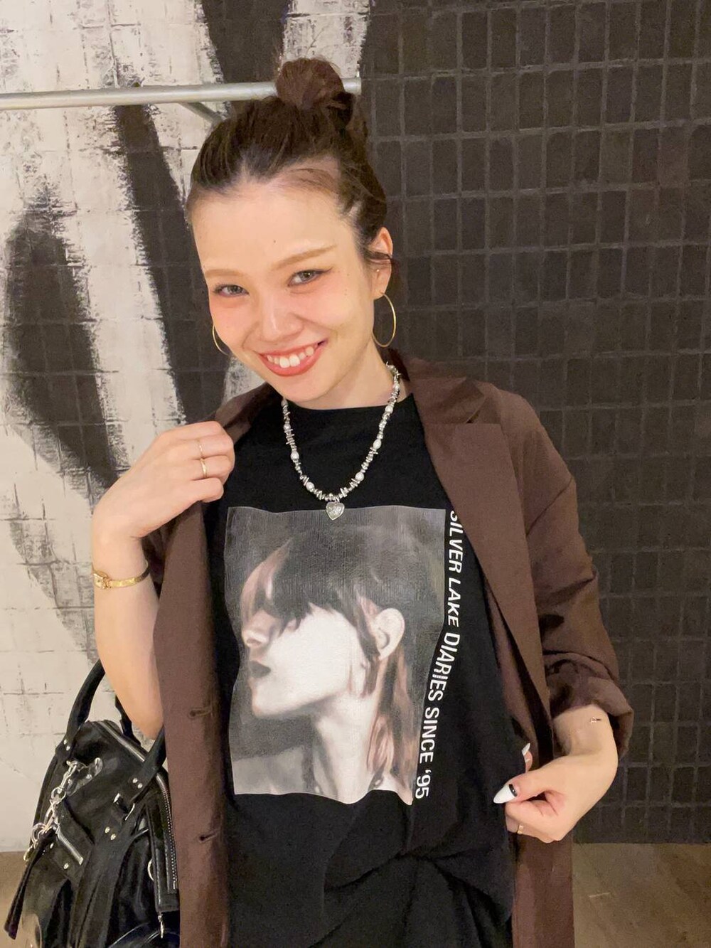 ブラック系のボストンバッグ、ブラック系のサンダル、ブラウン系のテーラードジャケットを着用したレディースの夏コーディネートの5枚目の写真