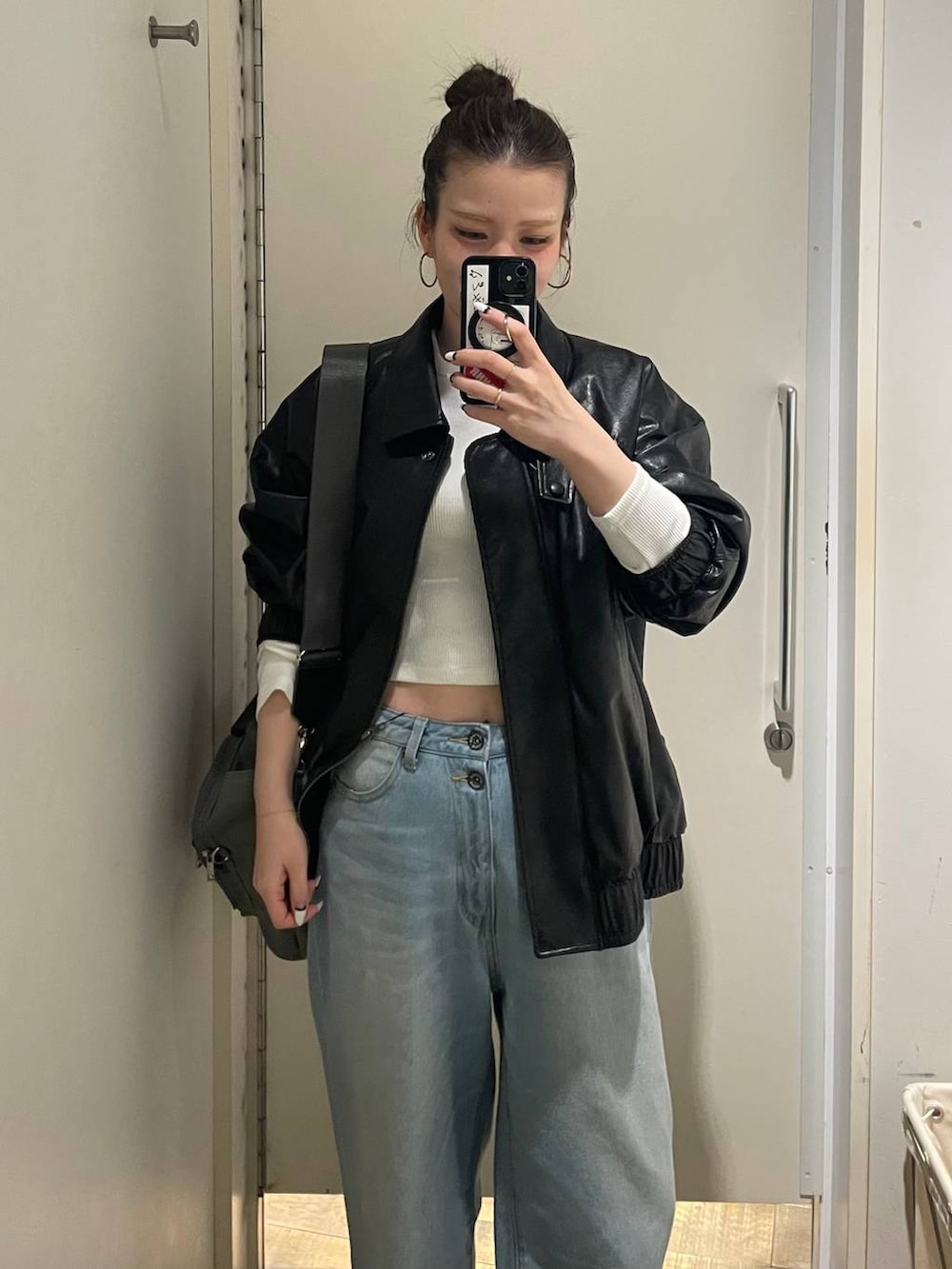 グリーン系のトートバッグ、ブルー系のデニムパンツ、ホワイト系のTシャツ/カットソーを着用したレディースの春コーディネートの2枚目の写真