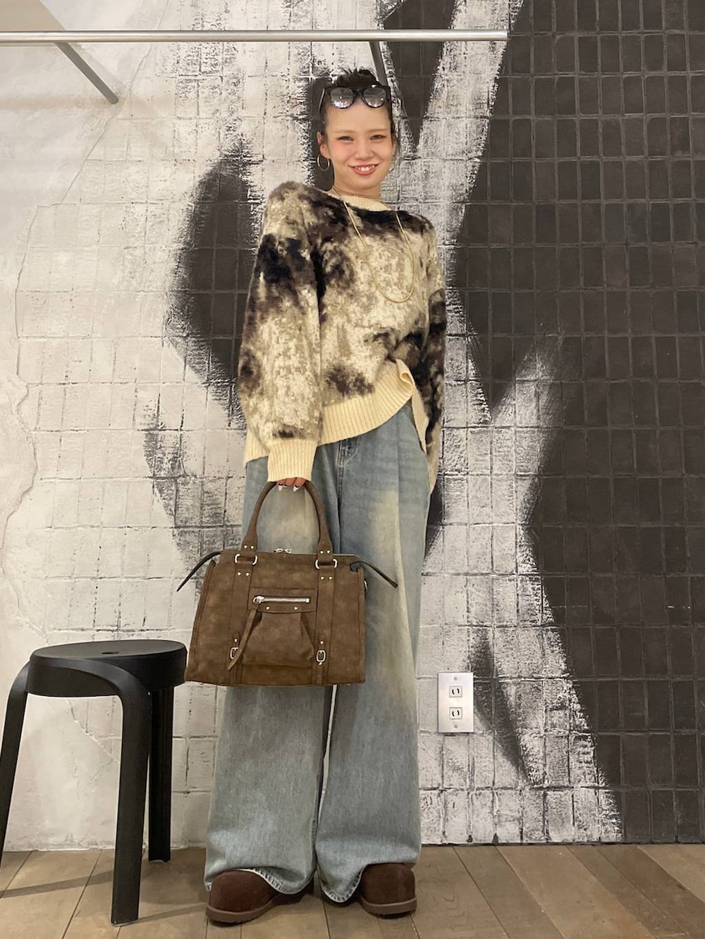 ブラウン系のニット/セーター、ブルー系のデニムパンツ、ブラウン系のボストンバッグを着用したレディースの冬コーディネートの6枚目の写真