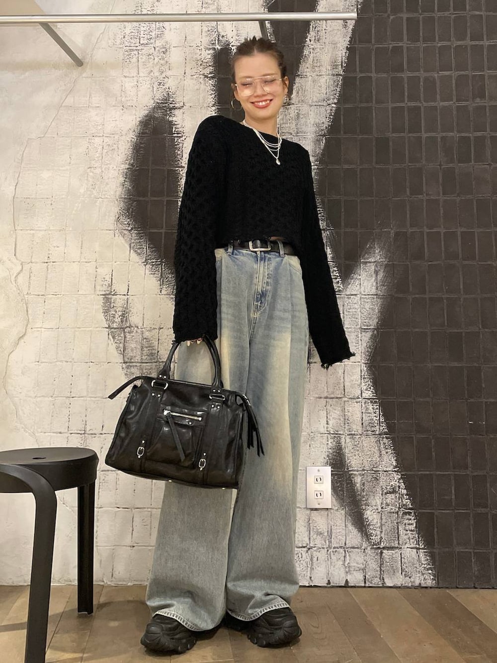 ブルー系のデニムパンツ、ブラック系のボストンバッグ、ブラック系のローファーを着用したレディースの秋コーディネートの4枚目の写真
