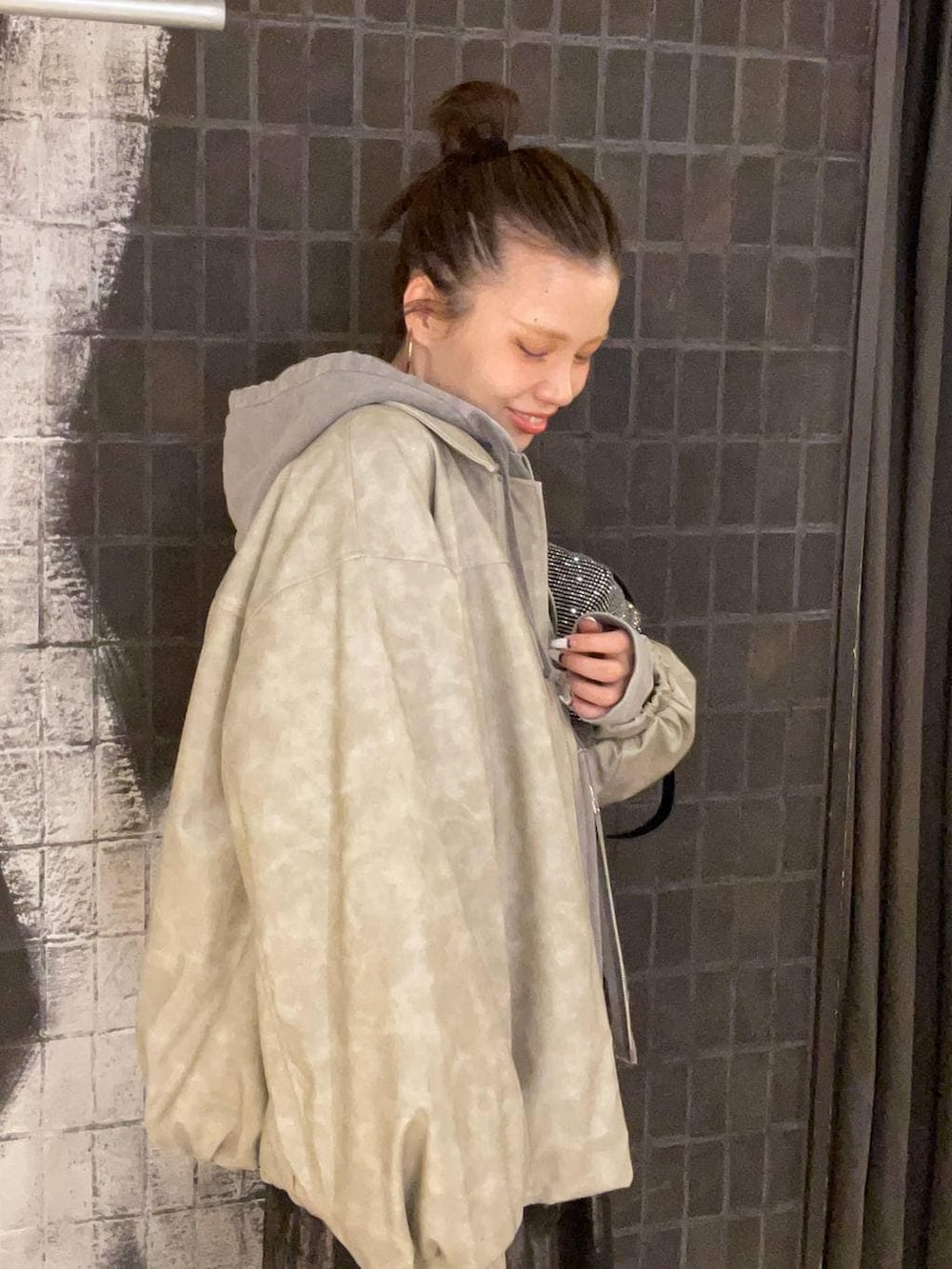 ベージュ系のブルゾン、グレー系のパーカー、ブラック系のブーツを着用したレディースの冬コーディネートの4枚目の写真