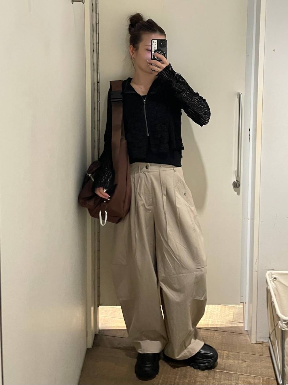 ブラウン系のショルダーバッグ、ブラック系のローファー、ベージュ系のその他パンツを着用したレディースの春コーディネートの6枚目の写真