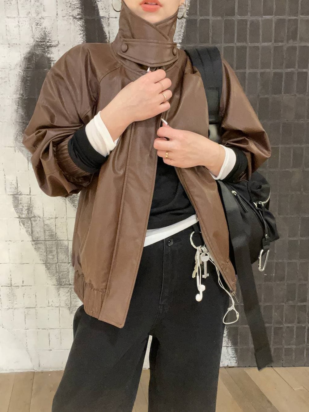 ブラック系のショルダーバッグ、ブラウン系のブルゾン、ブラック系のローファーを着用したレディースの春コーディネートの3枚目の写真