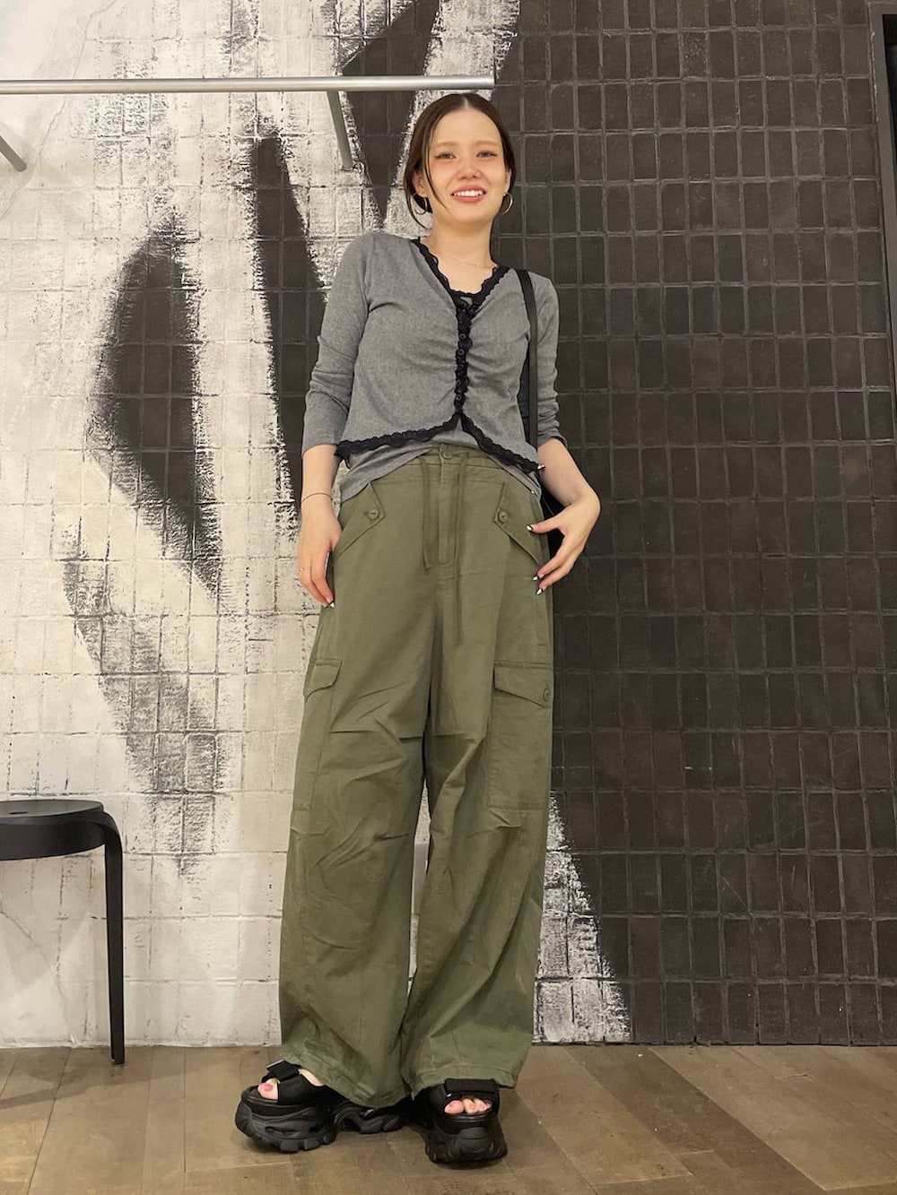 グリーン系のカーゴパンツ、ブラック系のバックパック/リュック、グレー系のカーディガン/ボレロを着用したレディースの夏コーディネートの4枚目の写真