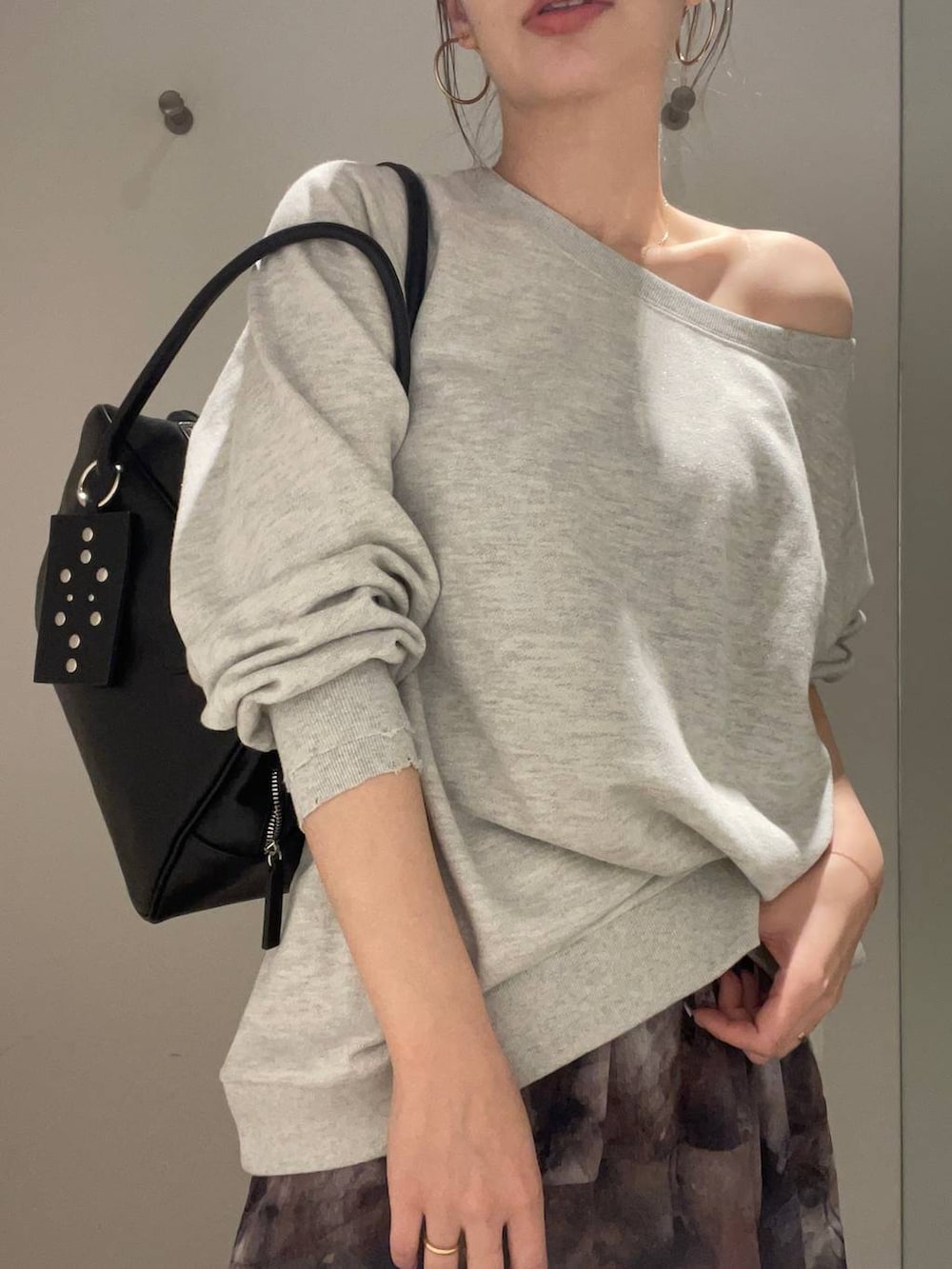 グレー系のスウェット、ブラック系のスカート、ブラック系のボストンバッグを着用したレディースの春コーディネートの4枚目の写真