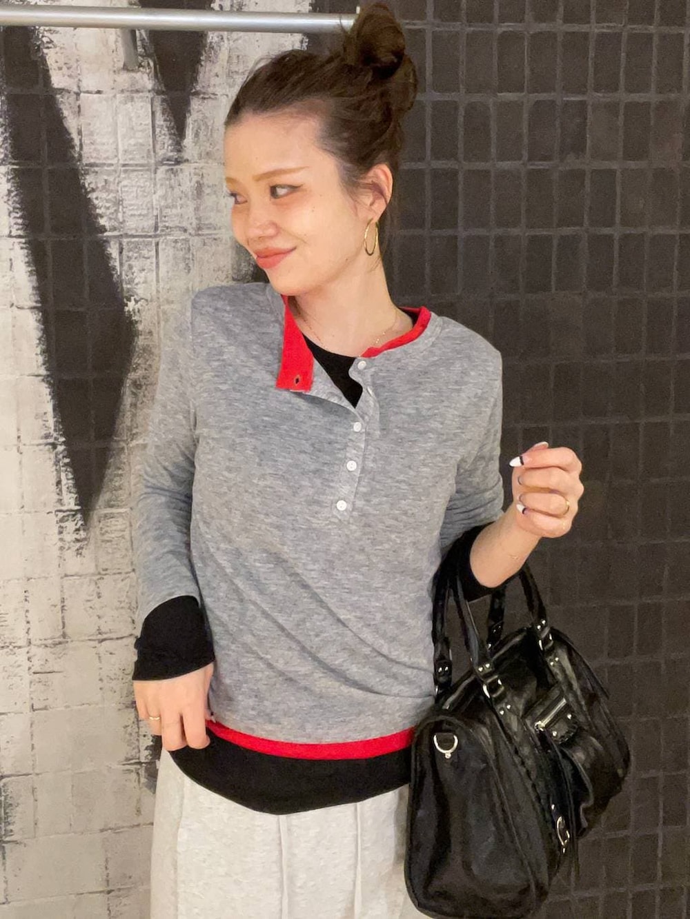 ブラック系のスニーカー、ブラック系のボストンバッグ、グレー系のスカートを着用したレディースの春コーディネートの7枚目の写真