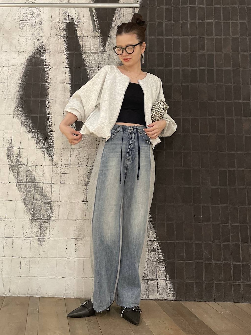 グレー系のスウェット、ブラック系のキャミソール、ブラック系のパンプスを着用したレディースの冬コーディネートの5枚目の写真