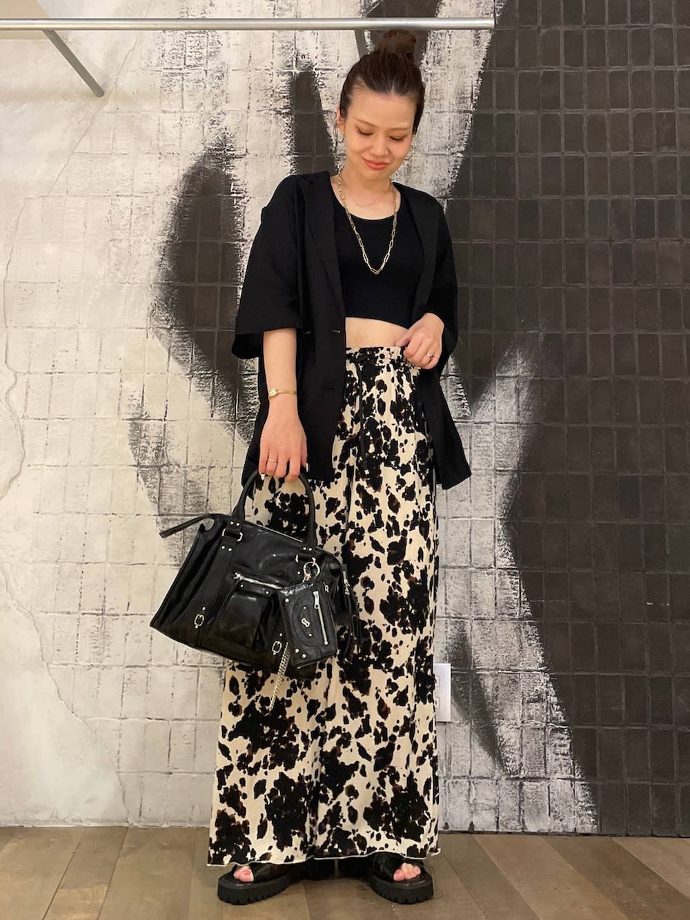 ブラック系のタンクトップ、ブラック系のボストンバッグ、ブラック系のサンダルを着用したレディースの夏コーディネートの6枚目の写真