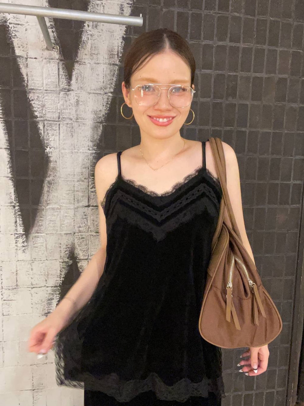 ブラック系のその他パンツ、ブラウン系のボストンバッグ、ブラック系のキャミソールを着用したレディースの夏コーディネートの2枚目の写真