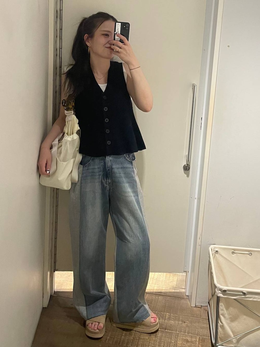 ブルー系のデニムパンツ、ホワイト系のタンクトップ、ベージュ系のサンダルを着用したレディースの春コーディネートの4枚目の写真