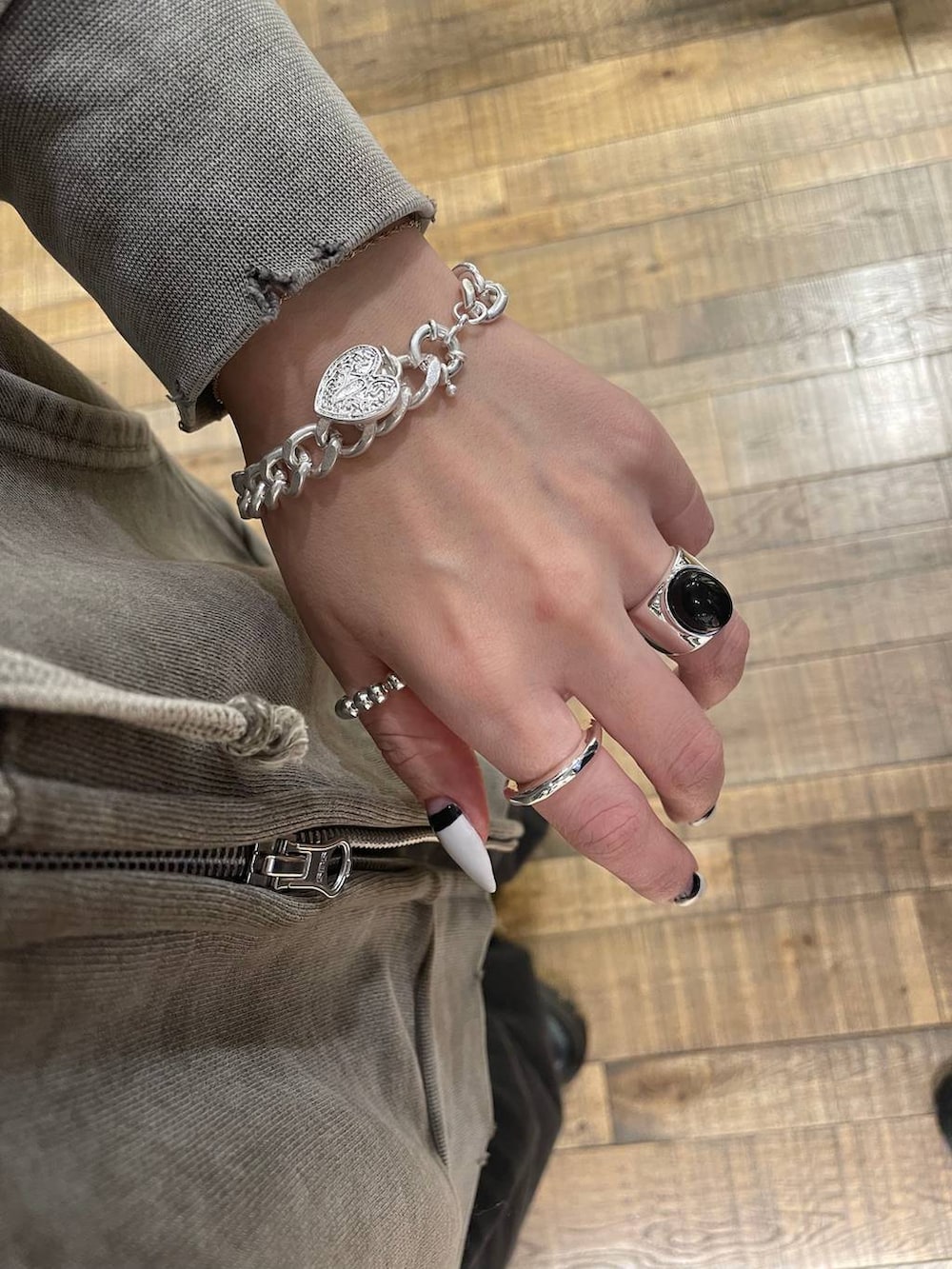 ブラック系のブルゾン、グレー系のパーカー、グレー系のデニムパンツを着用したレディースの冬コーディネートの5枚目の写真