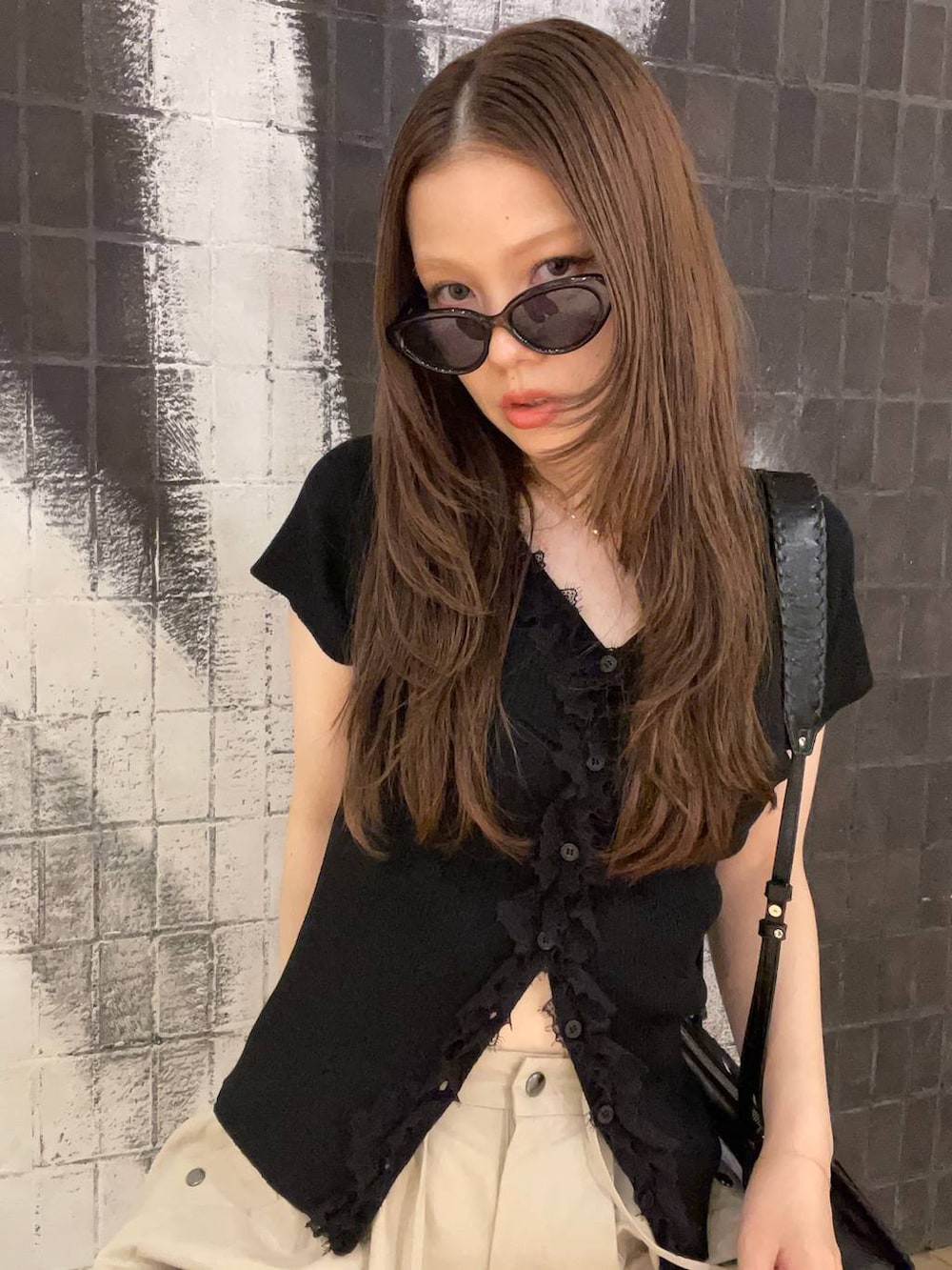 ベージュ系のその他パンツ、ブラック系のショルダーバッグ、ブラック系のサンダルを着用したレディースの夏コーディネートの5枚目の写真