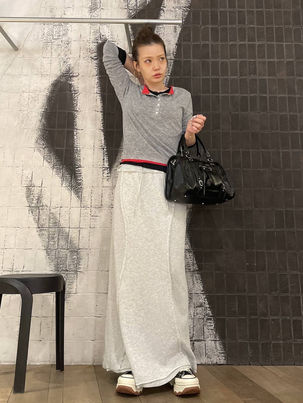 ブラック系のスニーカー、ブラック系のボストンバッグ、グレー系のスカートを着用したレディースの春コーディネートの3枚目の写真