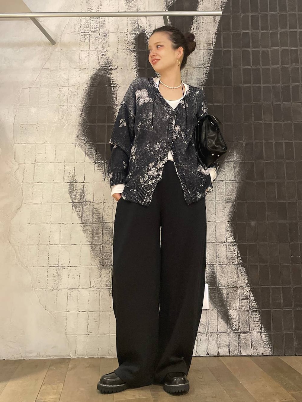 ホワイト系のTシャツ/カットソー、ブラック系のボストンバッグ、ブラック系のスラックスを着用したレディースの秋コーディネートの6枚目の写真