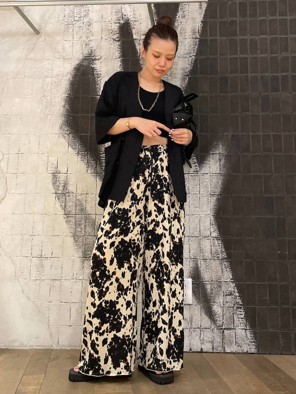 ブラック系のタンクトップ、ブラック系のボストンバッグ、ブラック系のサンダルを着用したレディースの夏コーディネートの2枚目の写真