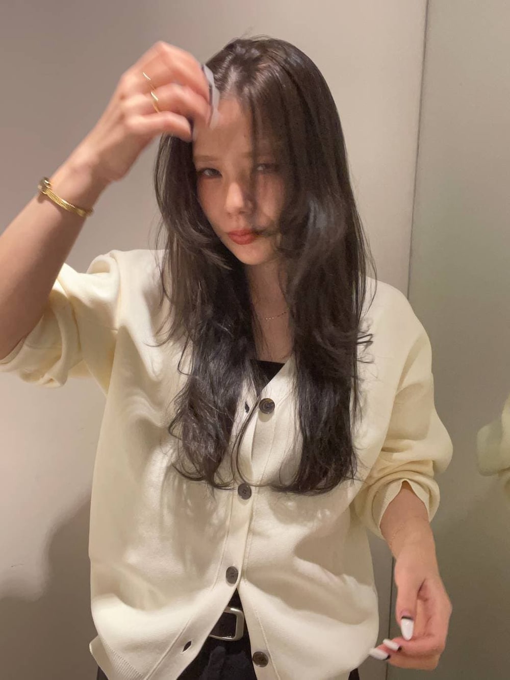 グレー系のデニムパンツ、ホワイト系のカーディガン/ボレロを着用したレディースの秋コーディネートの3枚目の写真