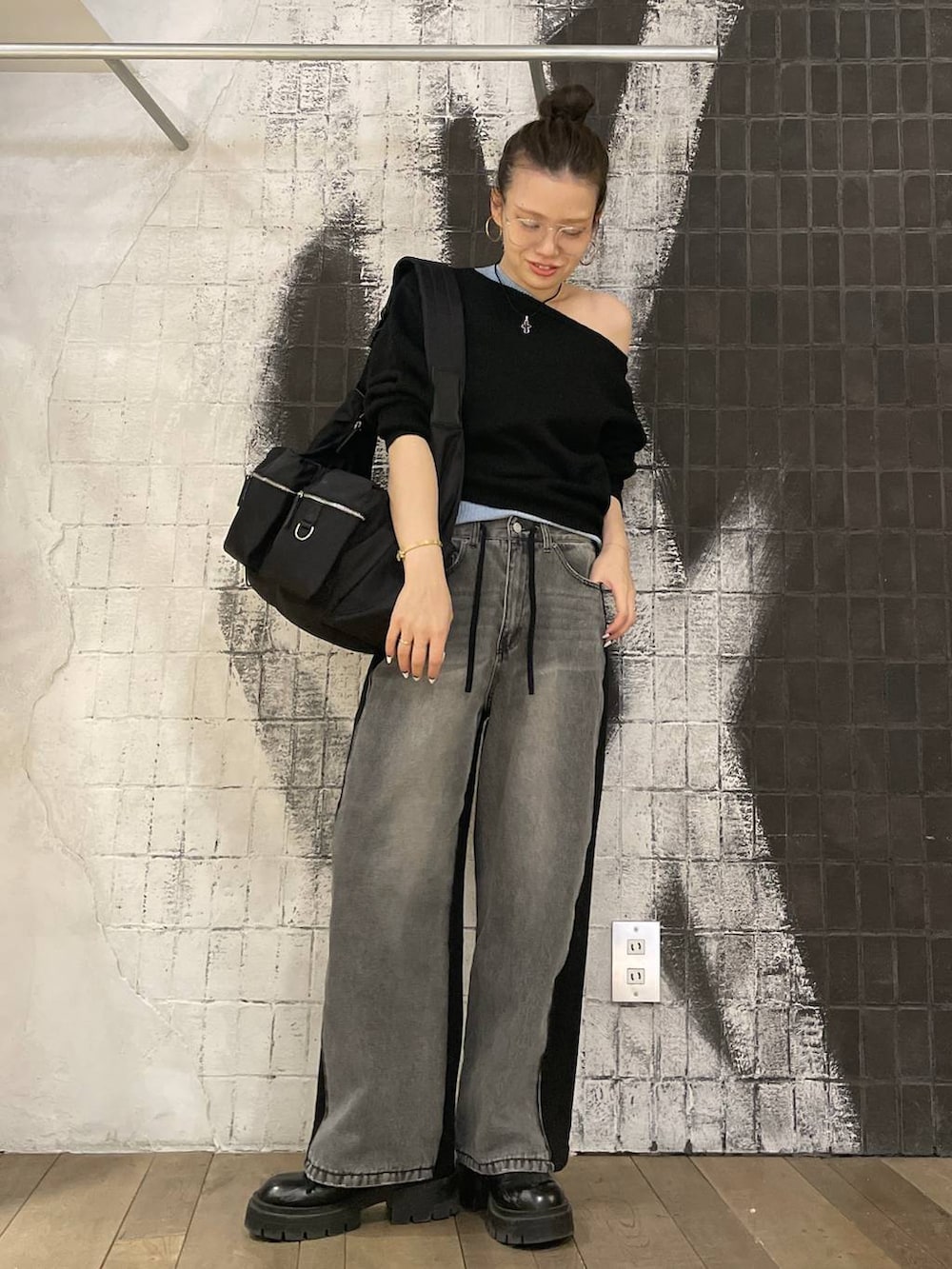 ブラック系のショルダーバッグ、ブラック系のデニムパンツ、ブラック系のブーツを着用したレディースの冬コーディネートの3枚目の写真