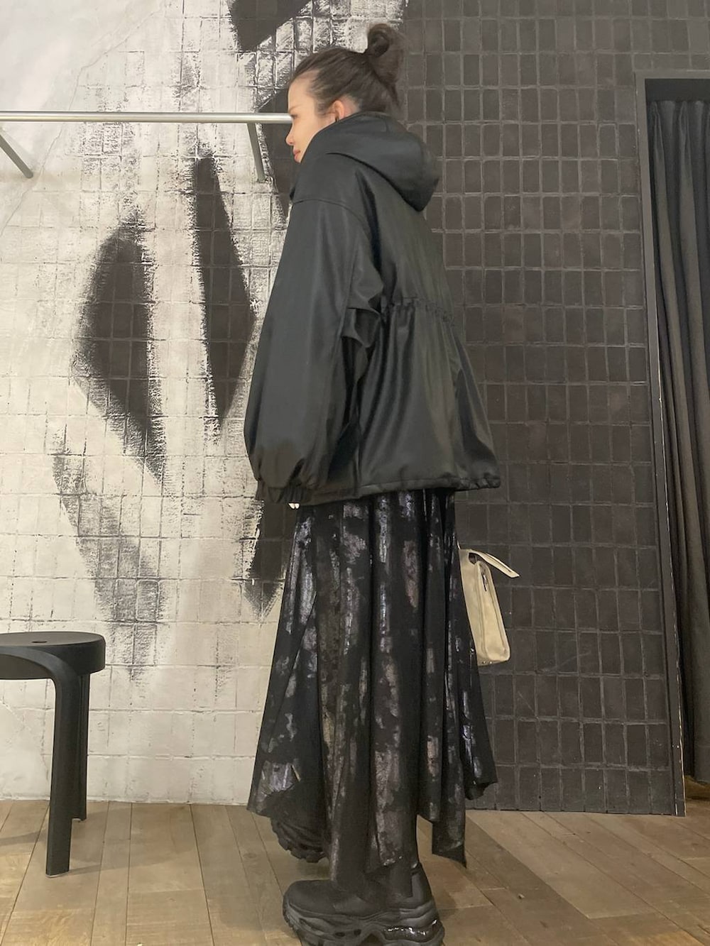 ベージュ系のボストンバッグ、ブラック系のブーツ、ブラック系のスカートを着用したレディースの冬コーディネートの3枚目の写真