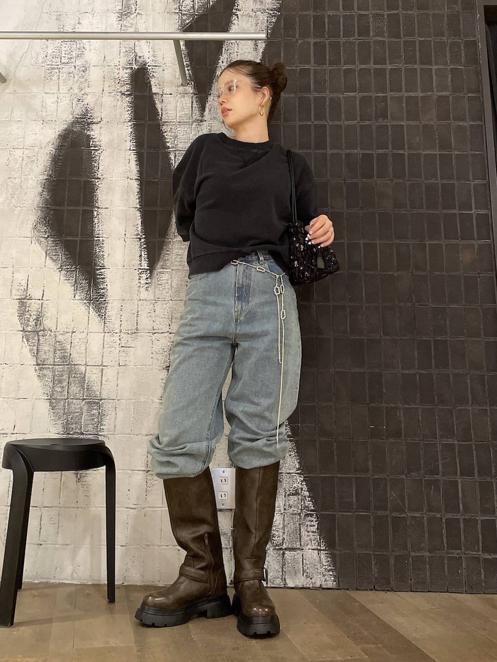 ブルー系のデニムパンツ、ブラック系のスウェット、ブラック系のショルダーバッグを着用したレディースの夏コーディネートの5枚目の写真