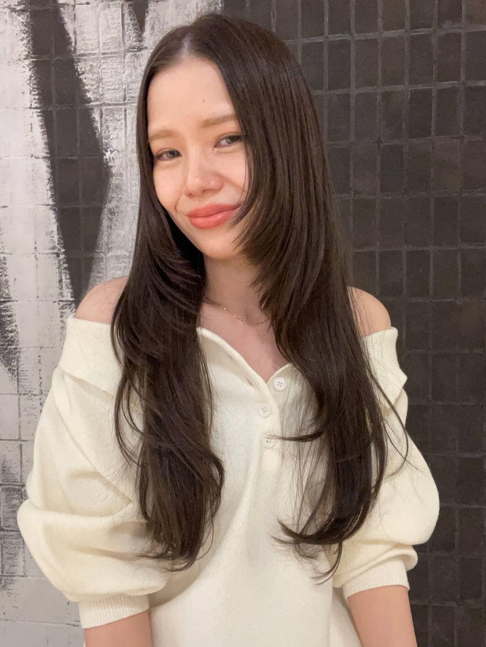 ホワイト系のニット/セーターを着用したレディースの春コーディネートの2枚目の写真