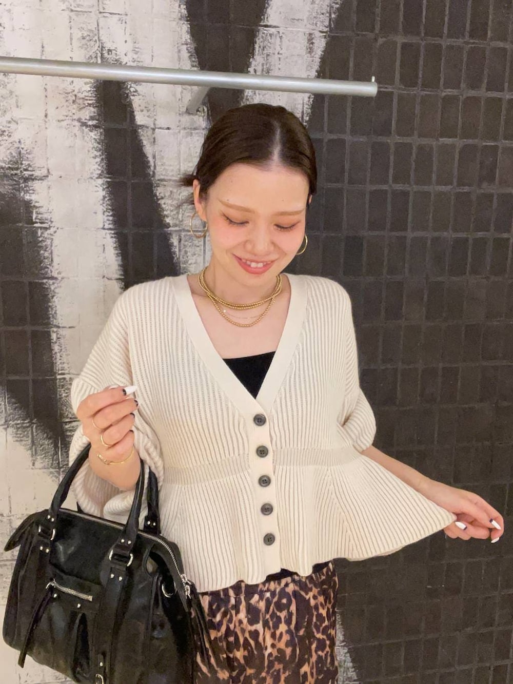 ブラック系のボストンバッグ、ブラウン系のその他シューズ、ホワイト系のカーディガン/ボレロを着用したレディースの冬コーディネートの4枚目の写真