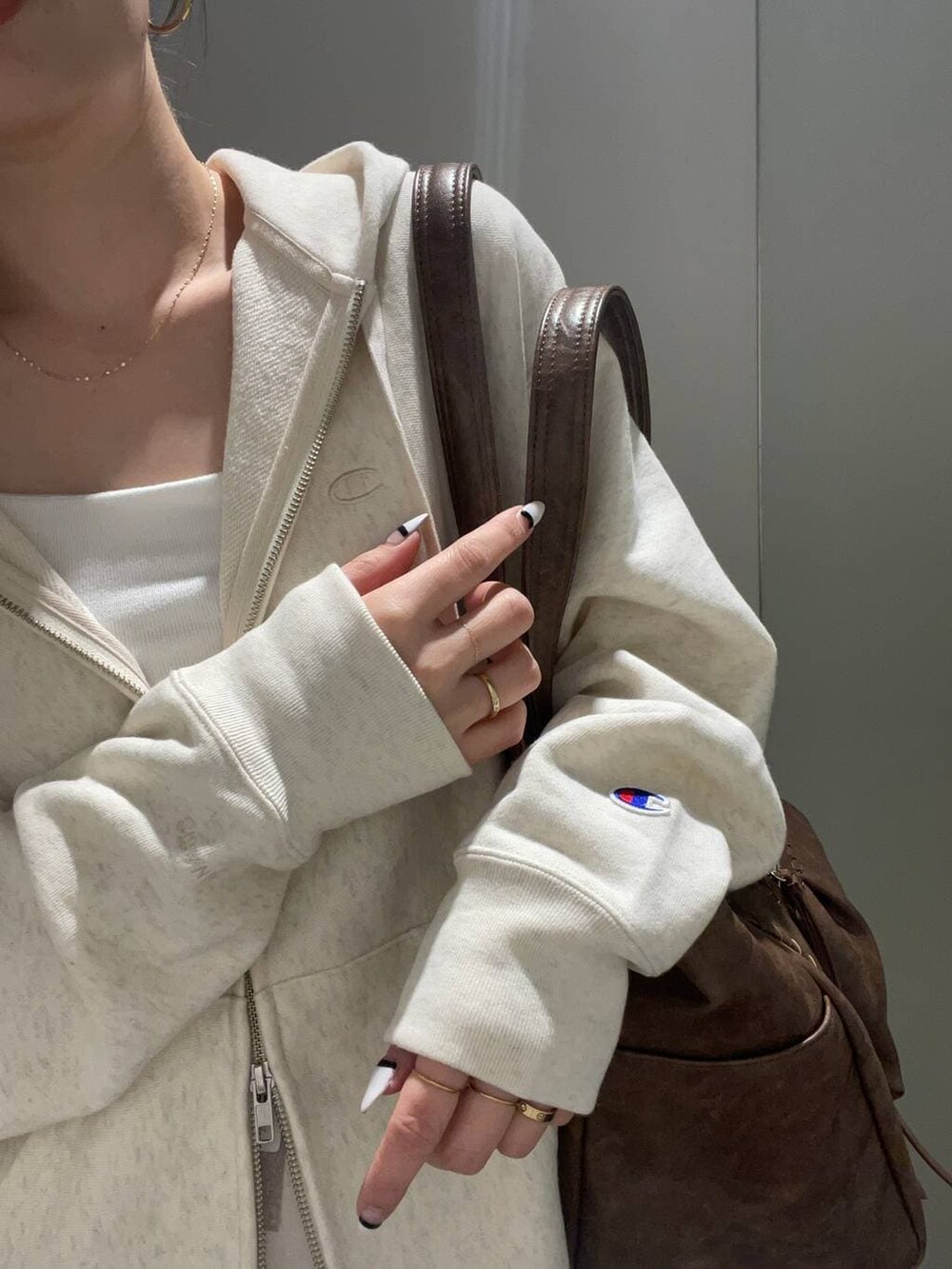 ベージュ系のパーカー、ホワイト系のキャミソール、ホワイト系のスカートを着用したレディースの冬コーディネートの3枚目の写真