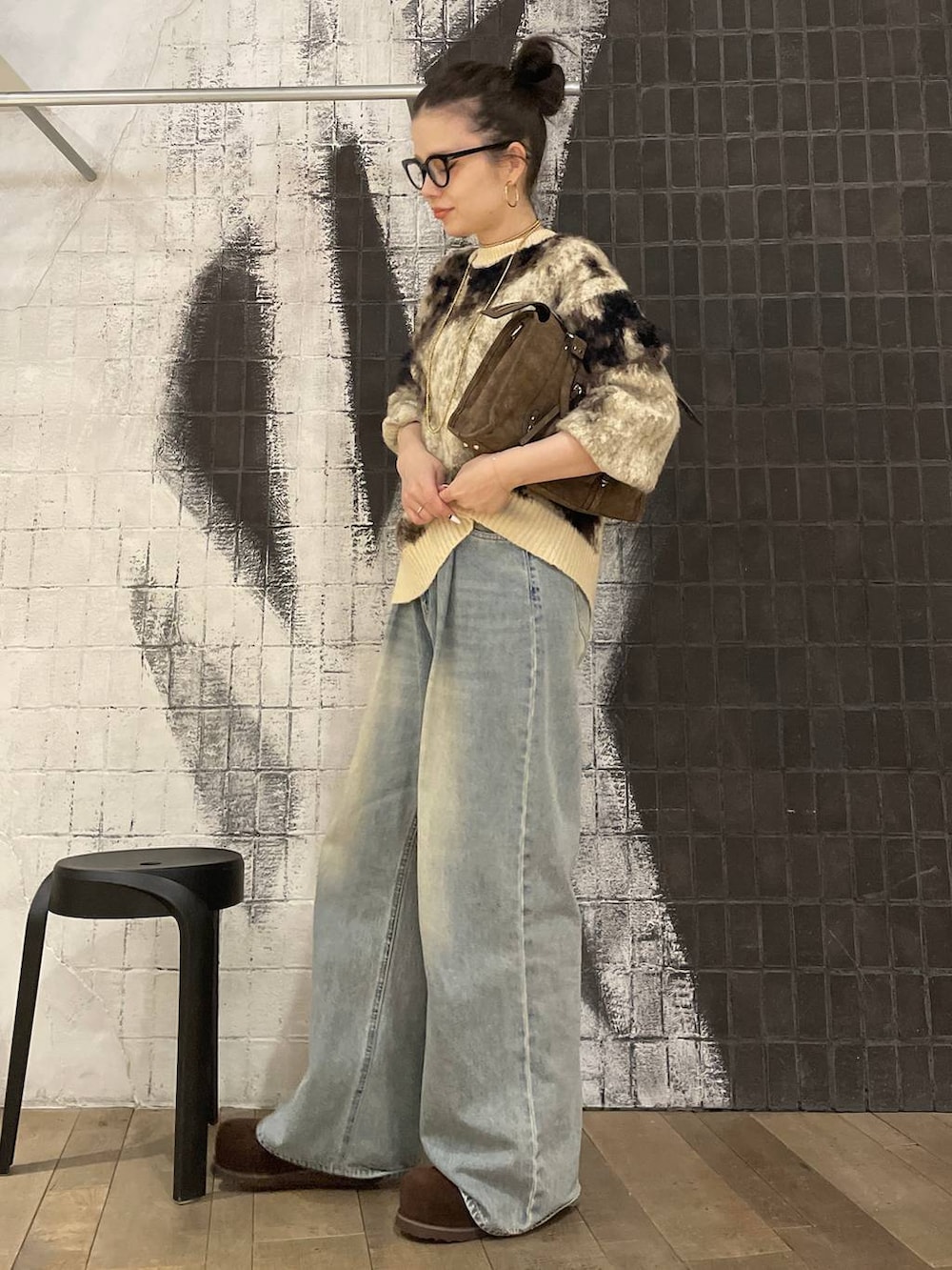 ブラウン系のニット/セーター、ブルー系のデニムパンツ、ブラウン系のボストンバッグを着用したレディースの冬コーディネートの4枚目の写真