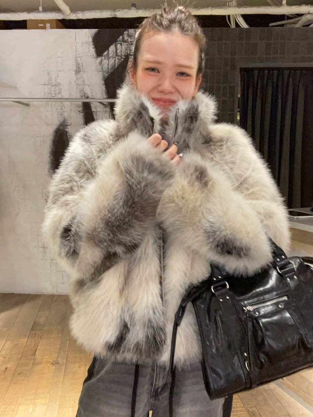 グレー系のブルゾン、ブラック系のボストンバッグ、ブラック系のデニムパンツを着用したレディースの冬コーディネートの8枚目の写真